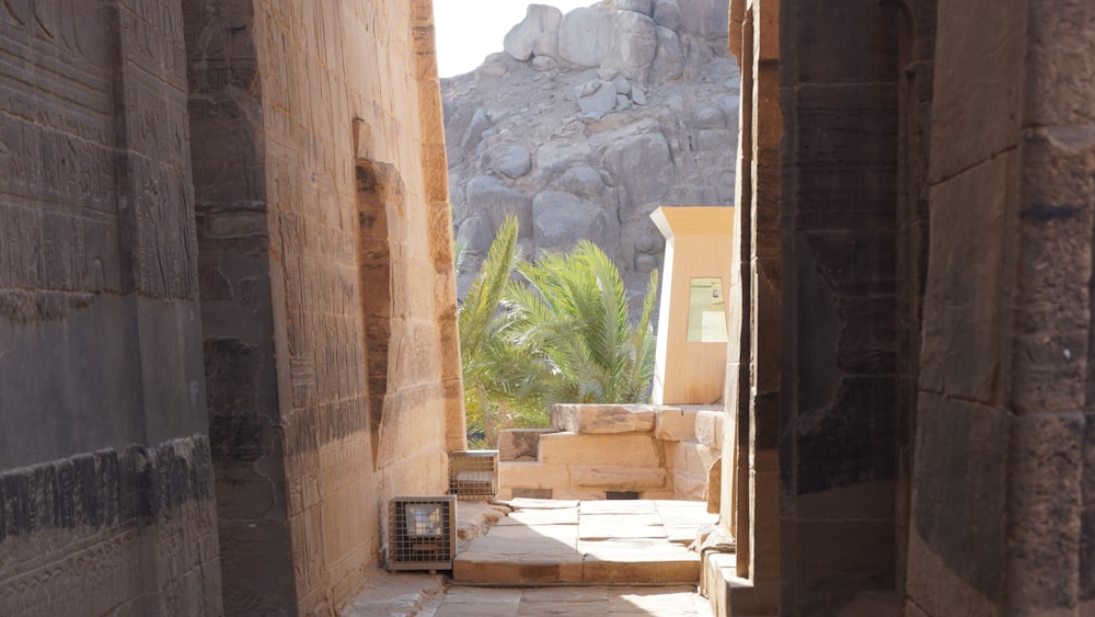 a narrow alley way with stone steps leading to a rock formation