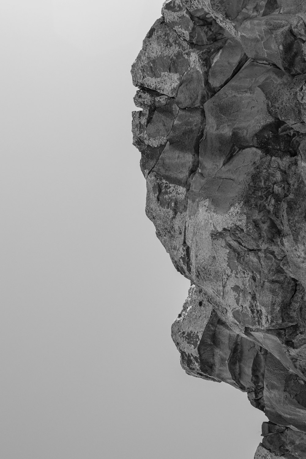 Ein Schwarz-Weiß-Foto einer Person, die auf dem Gipfel eines Berges steht