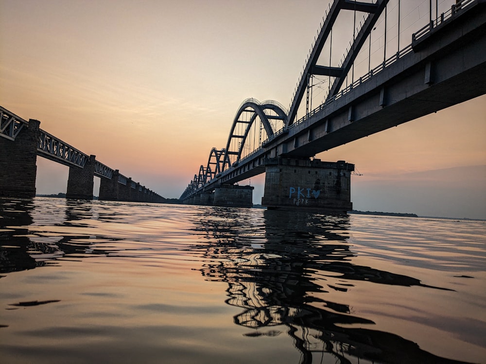 a bridge over a body of water at sunset