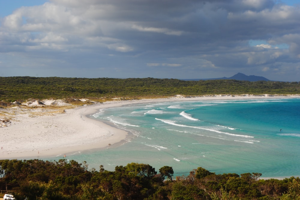 a view of a sandy beach with blue water