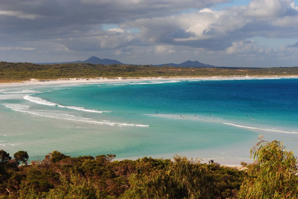 a view of a beach with people in the water