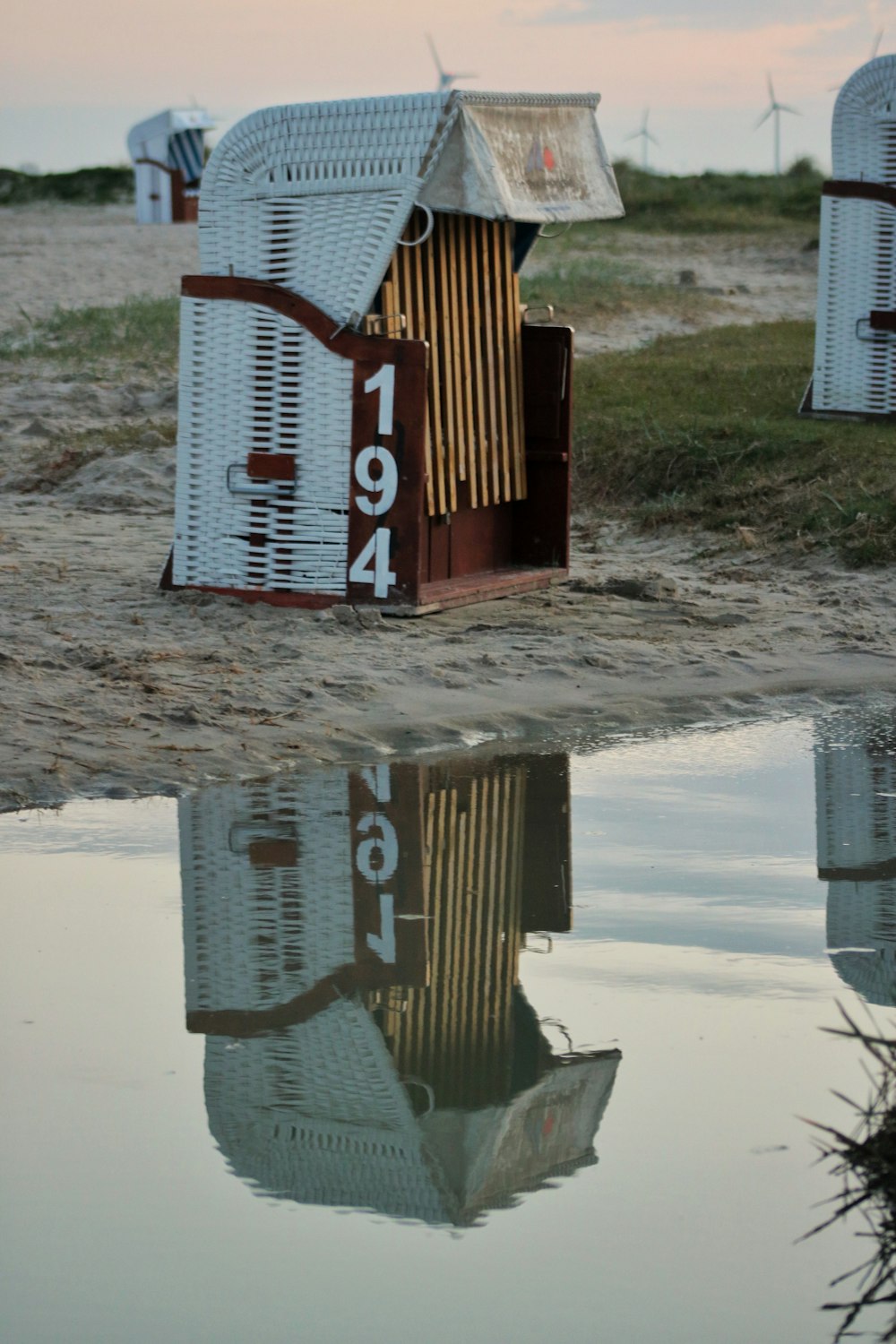 a number of mailboxes on a beach near a body of water