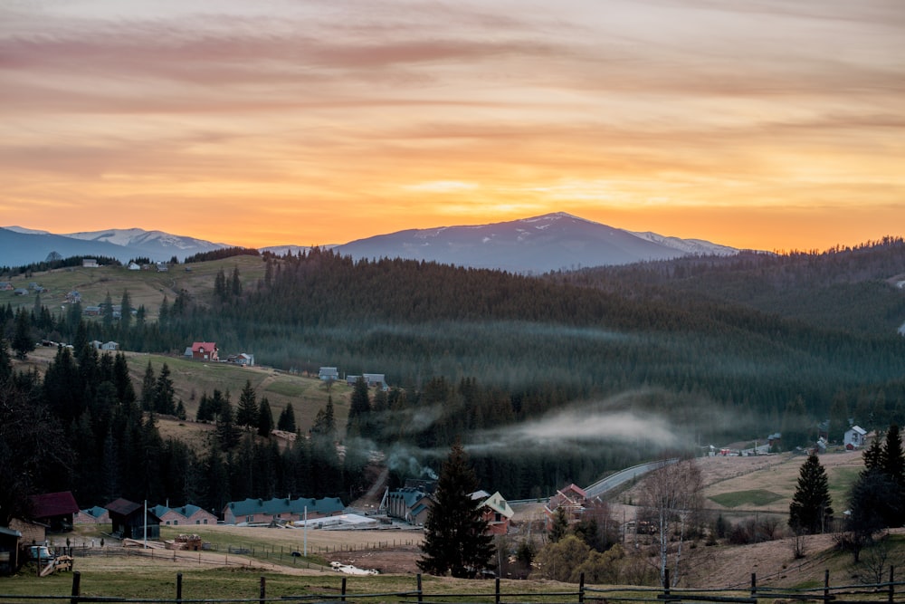 the sun is setting over a mountain valley