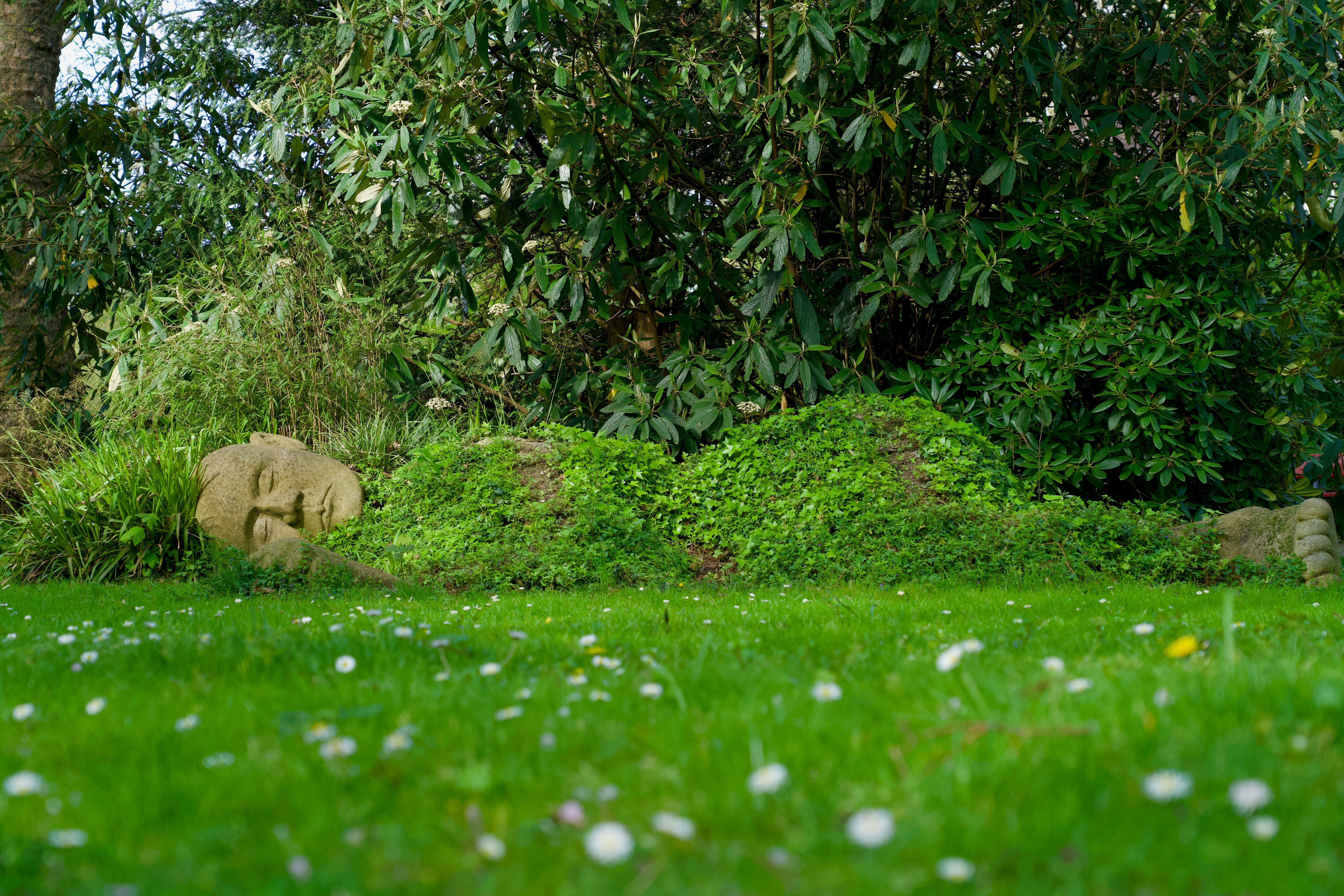 a statue of an elephant in the middle of a grassy area