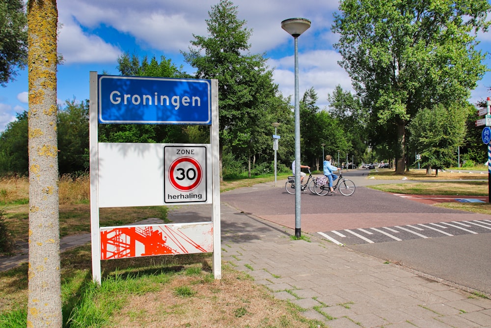 a blue sign sitting on the side of a road