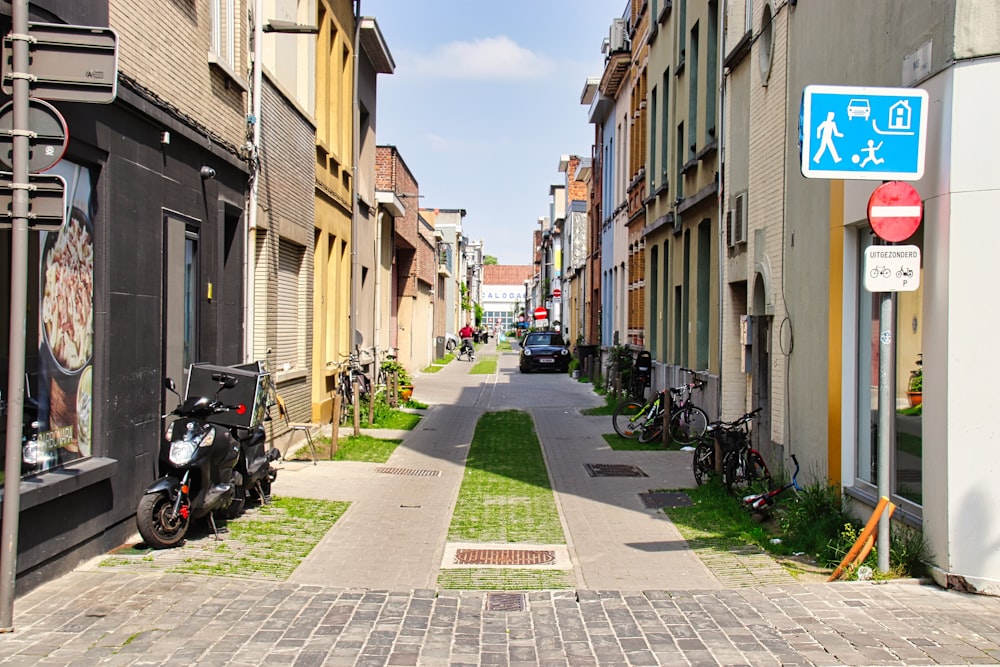 a street lined with parked motorcycles next to tall buildings