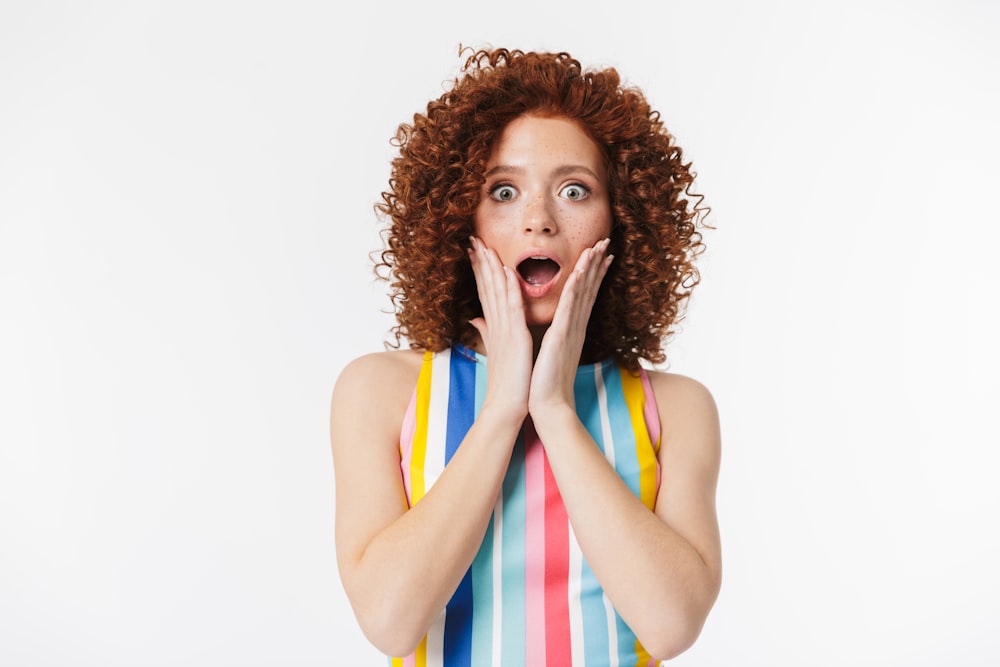a woman with curly hair is making a surprised face