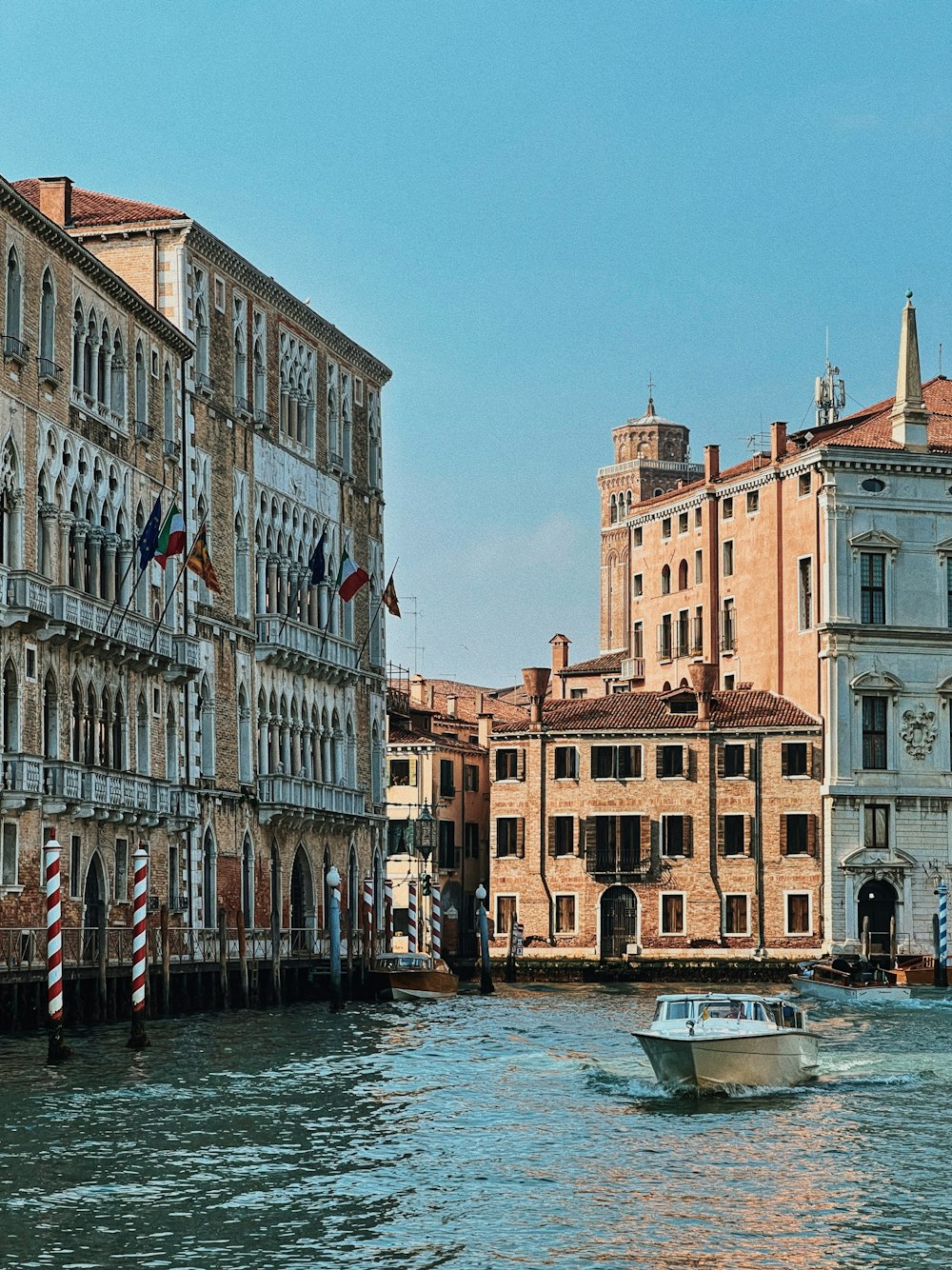 a boat traveling down a river next to tall buildings