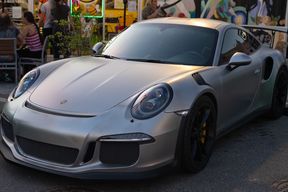 a silver sports car parked on the side of the road