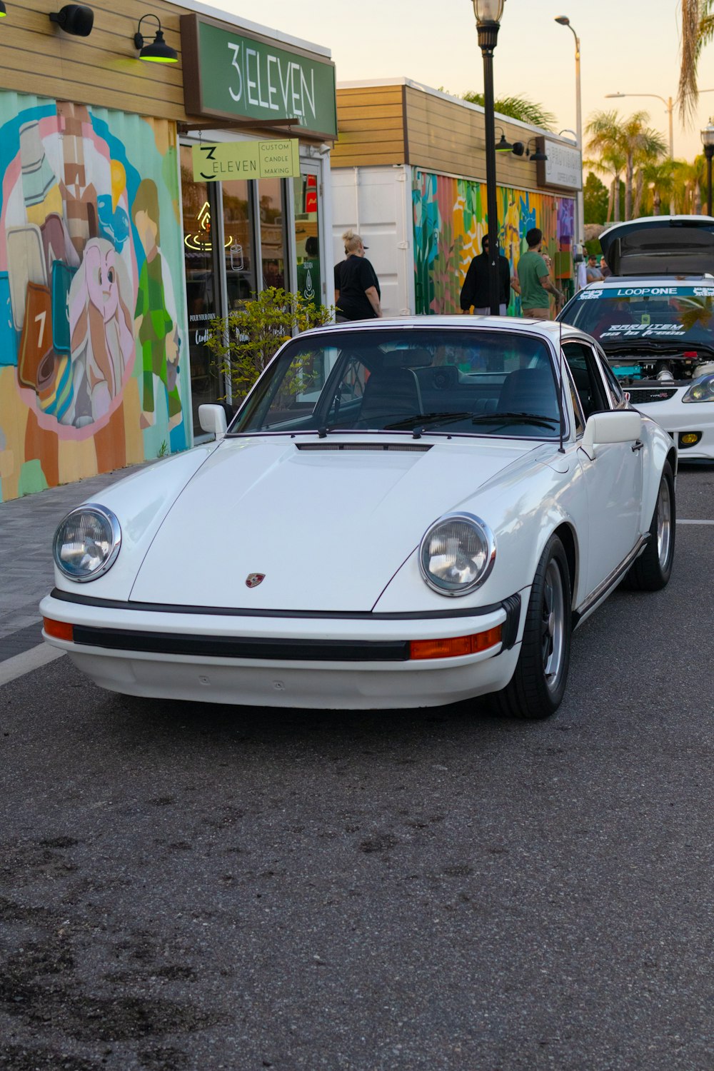 a white porsche parked on the side of the road