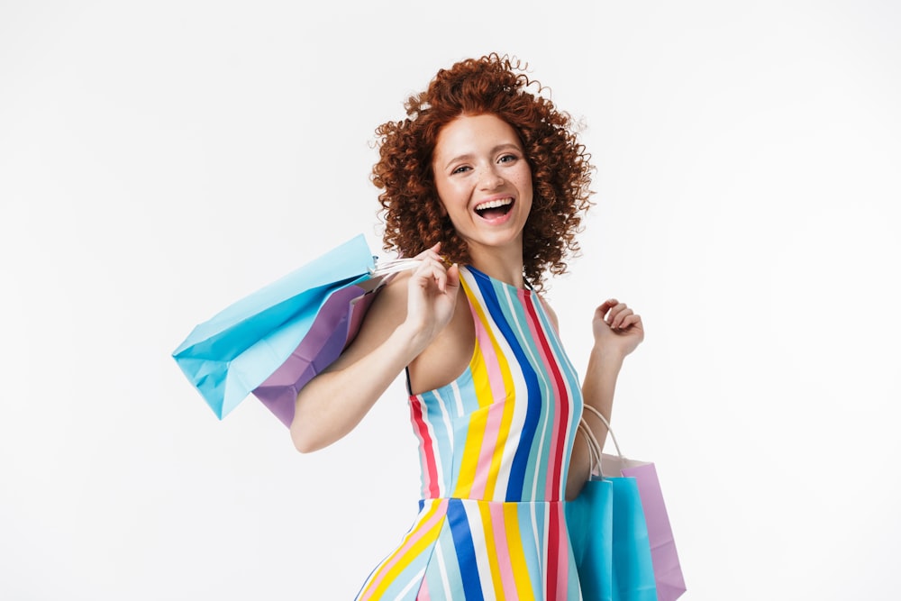 a woman in a colorful dress holding shopping bags