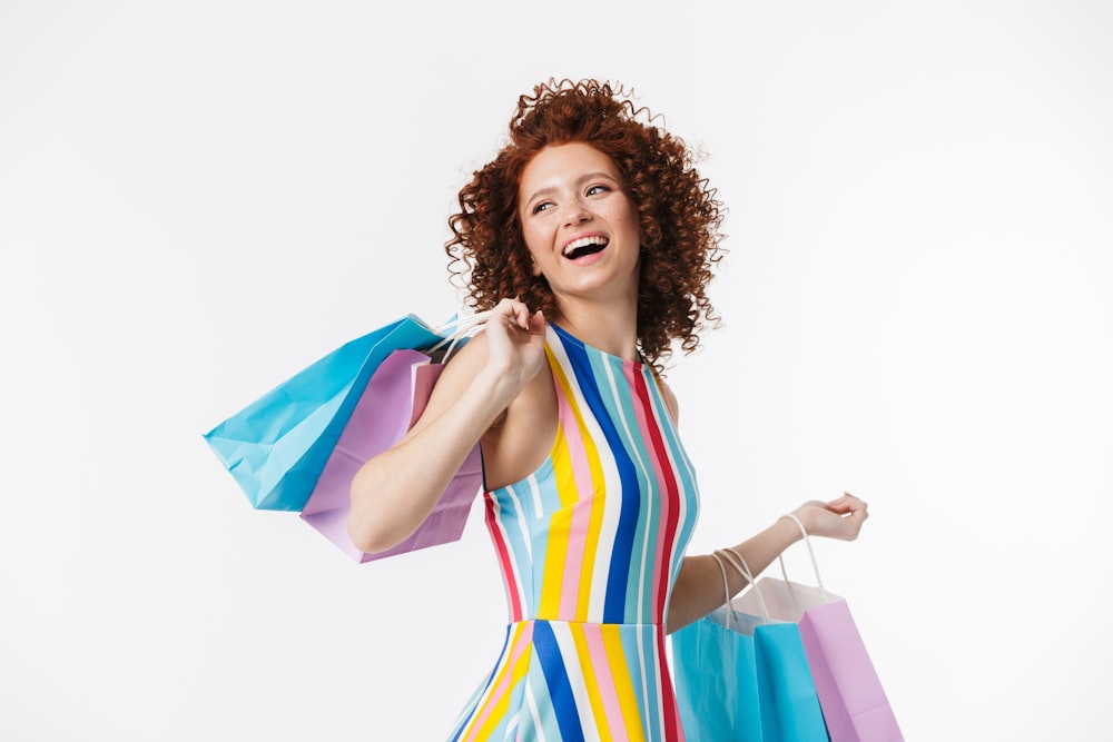 a woman in a colorful dress holding shopping bags