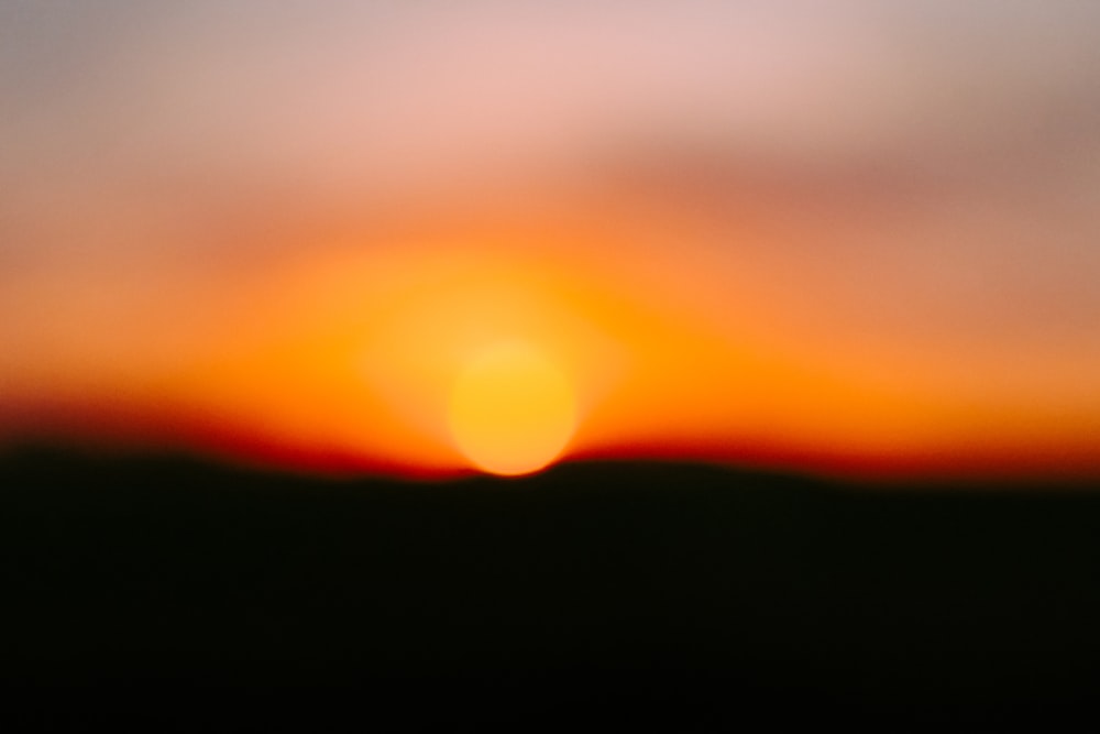a blurry photo of the sun setting in the sky