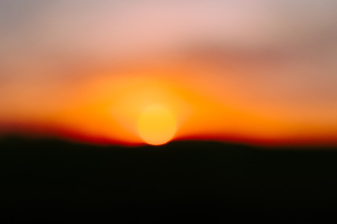 a blurry photo of the sun setting in the sky