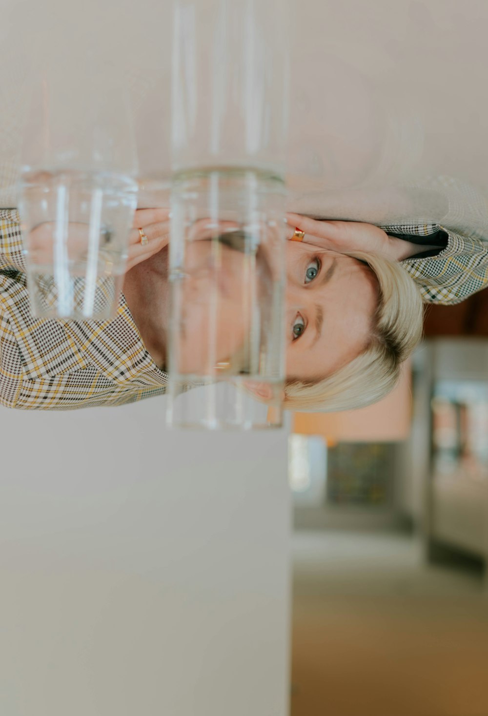 a woman standing behind a stack of glasses