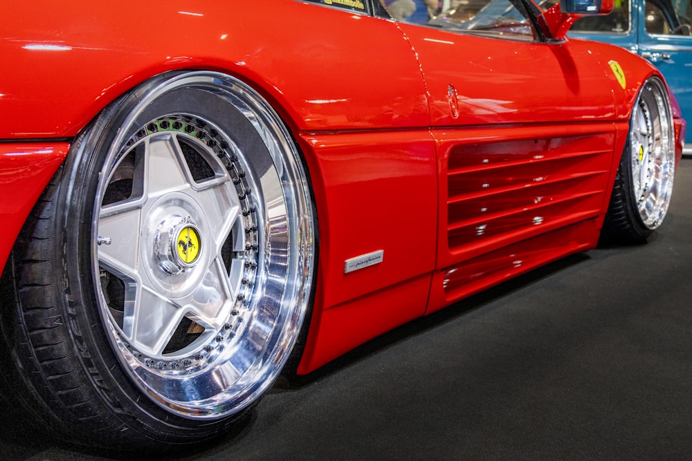 a close up of a red sports car on display