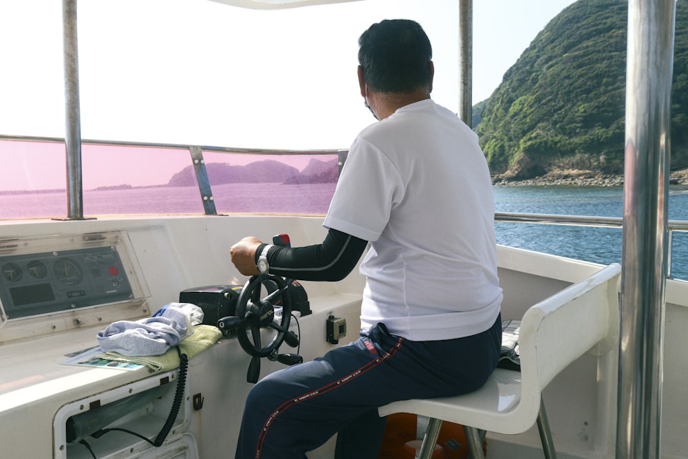 a man sitting on the steering wheel of a boat
