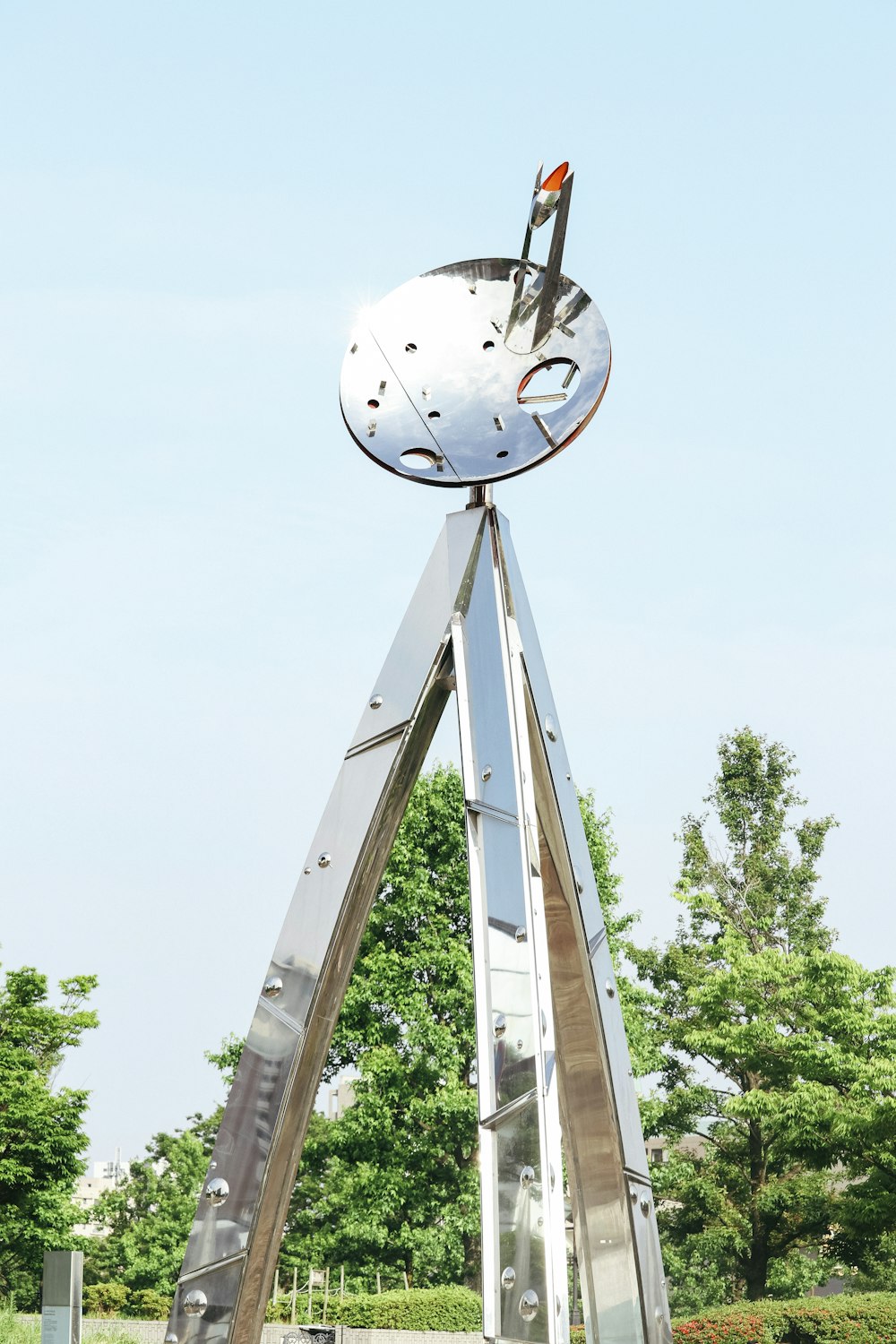 a large metal sculpture with a clock on top of it