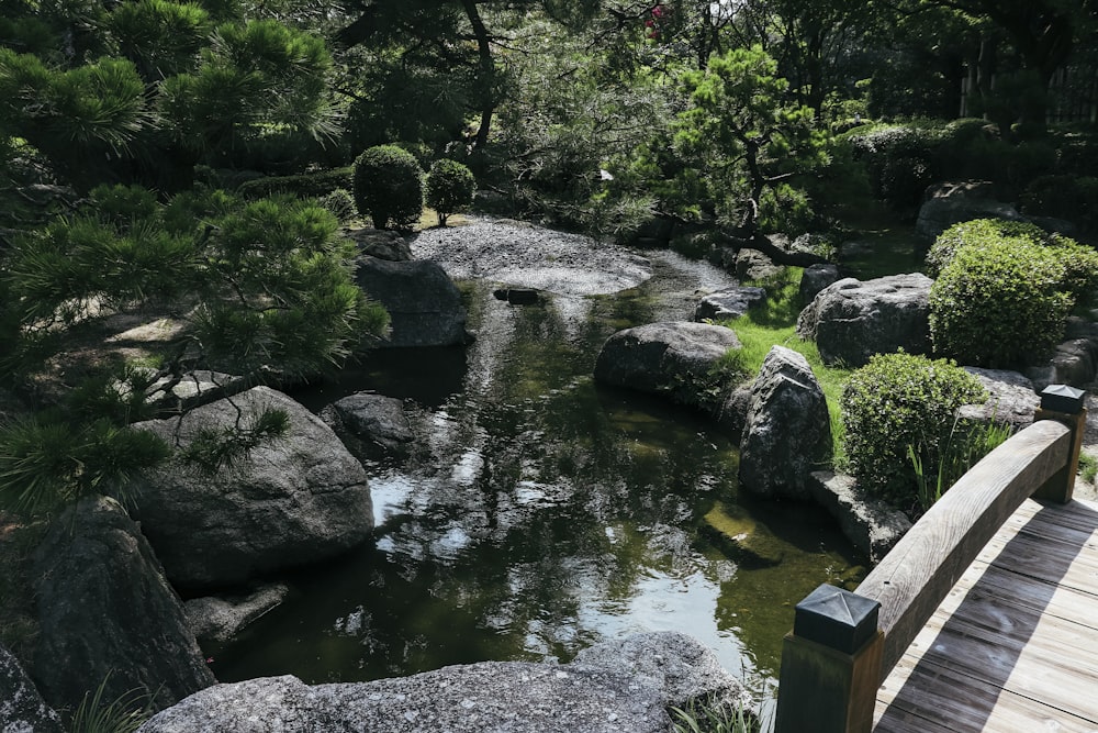 a wooden bridge over a small river surrounded by rocks