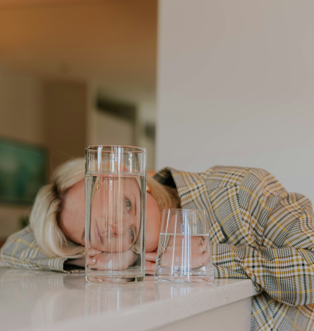 a woman leaning on a counter with a glass