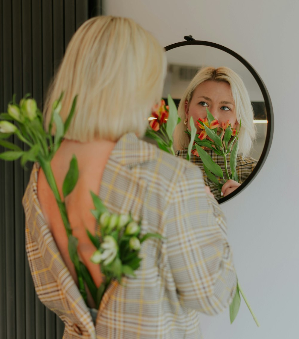 a woman looking at herself in the mirror