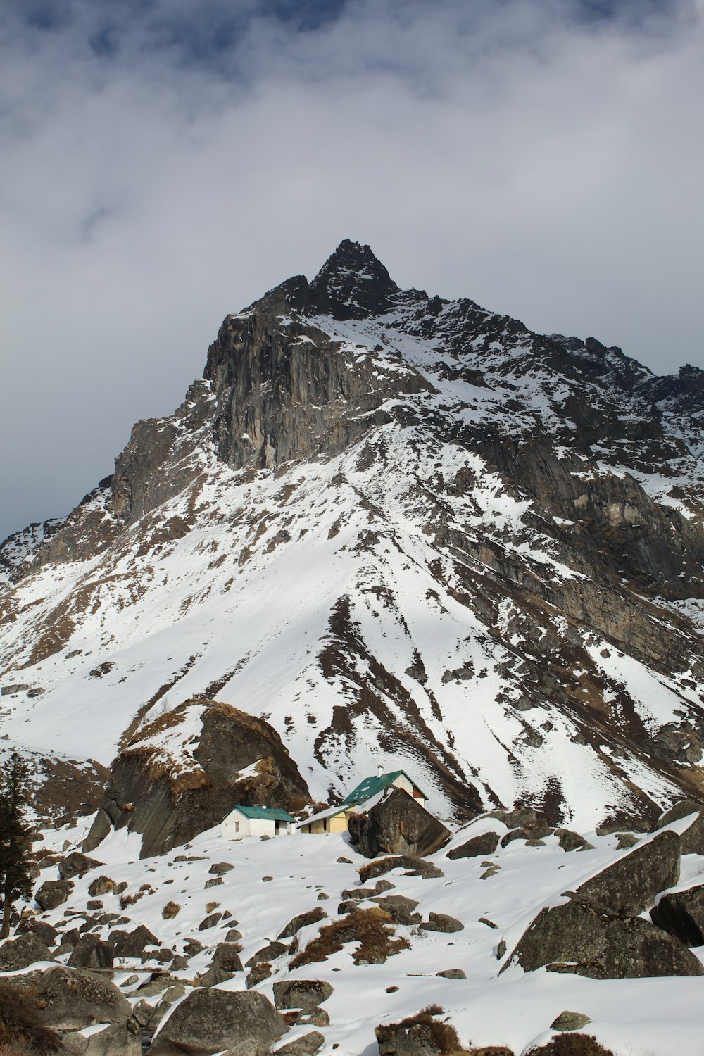 a snow covered mountain with a tent in the foreground