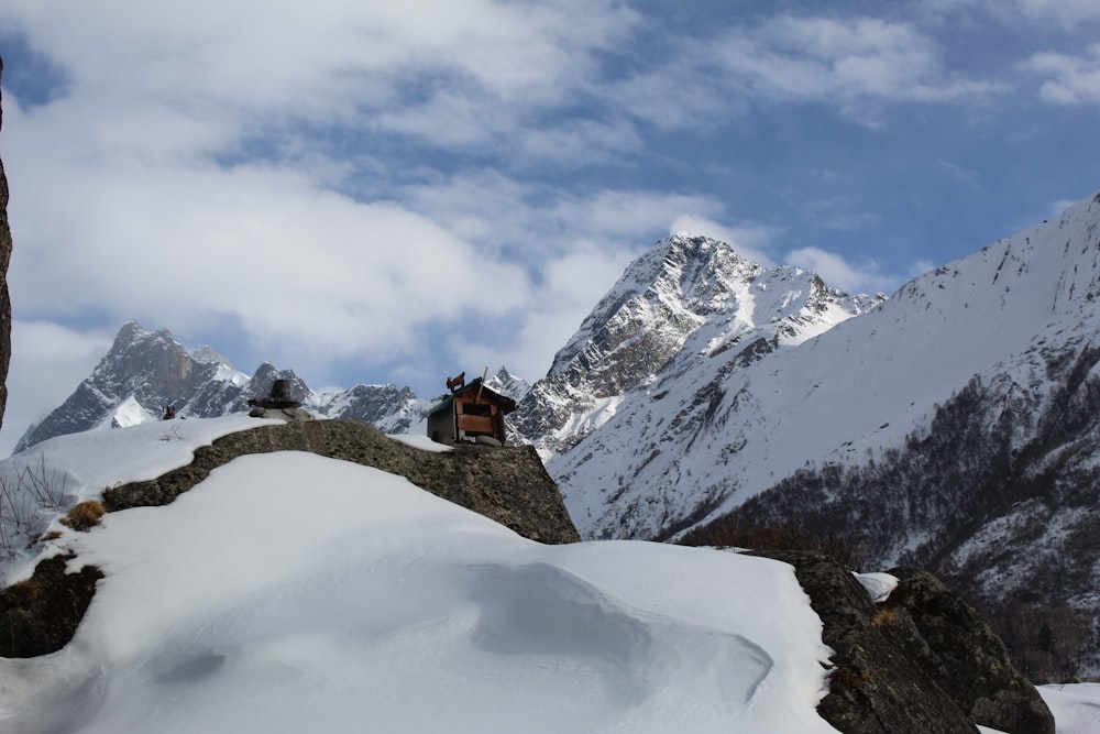 un uomo seduto in cima a una montagna coperta di neve
