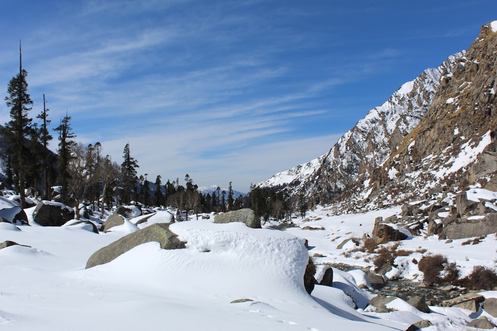 a mountain covered in snow and rocks under a blue sky