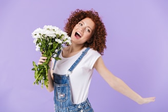 a woman holding a bunch of white flowers