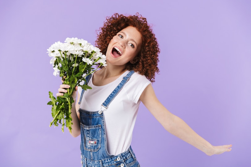 a woman holding a bunch of white flowers
