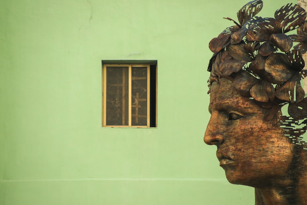 a statue of a woman with a bunch of leaves on her head