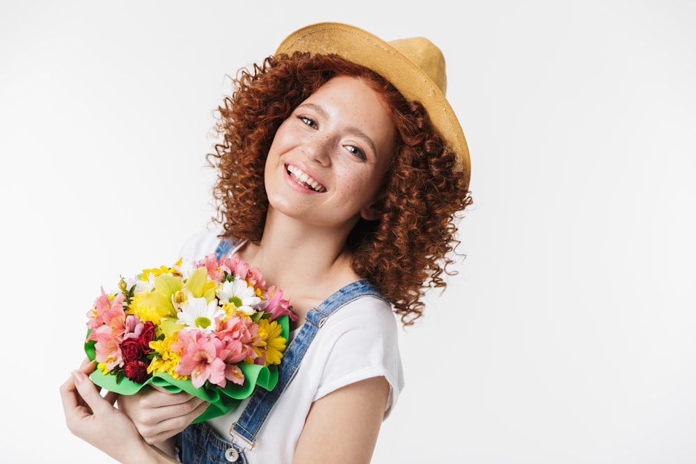 a woman holding a bunch of flowers in her hands