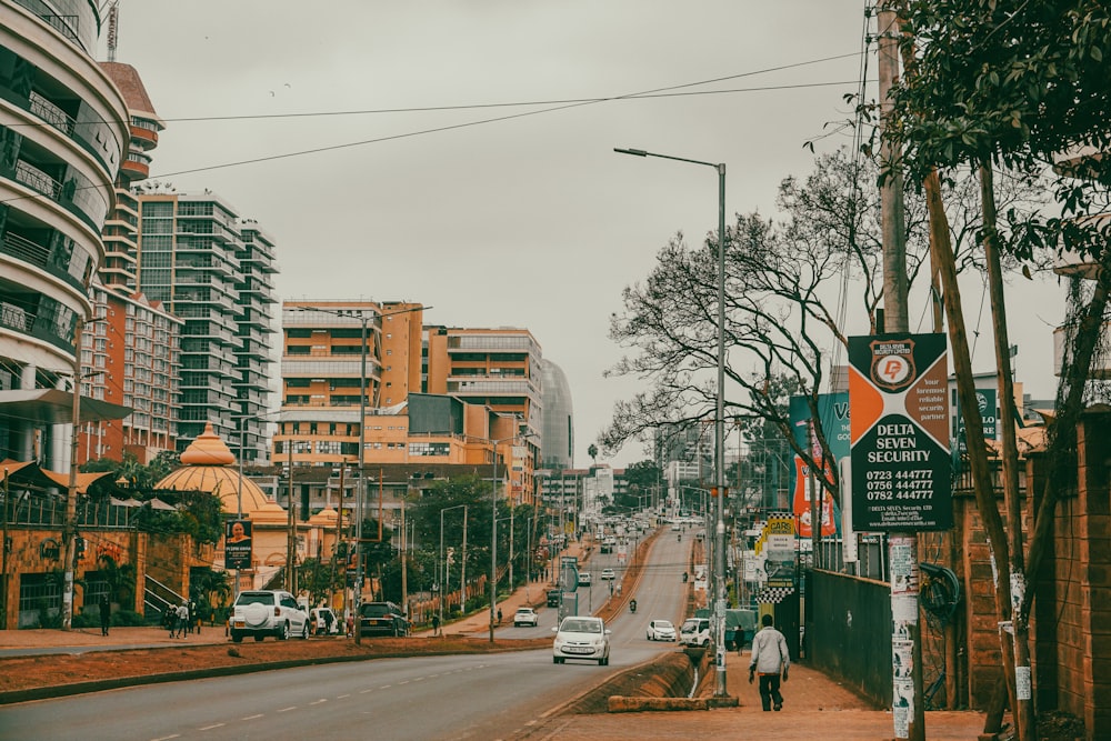 a man walking down a street next to tall buildings