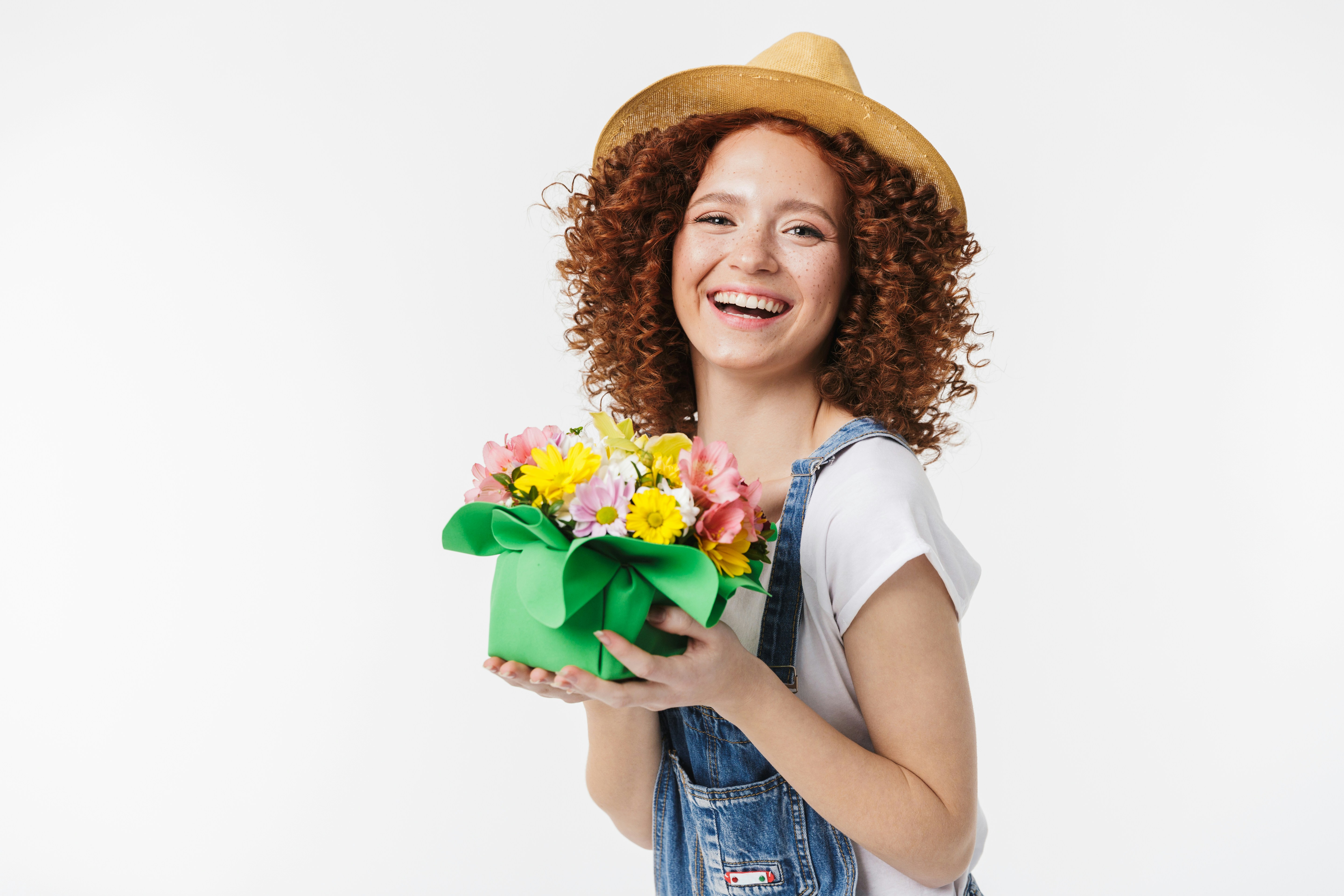 A person smiling and holding a bouquet of colorful spring flowers