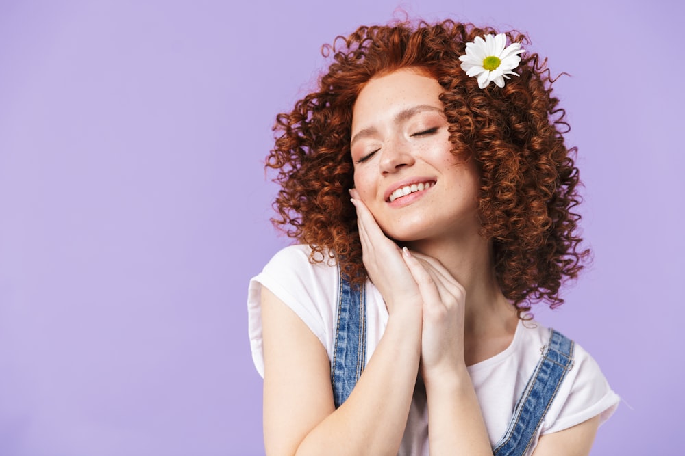 a woman with red hair and a daisy in her hair