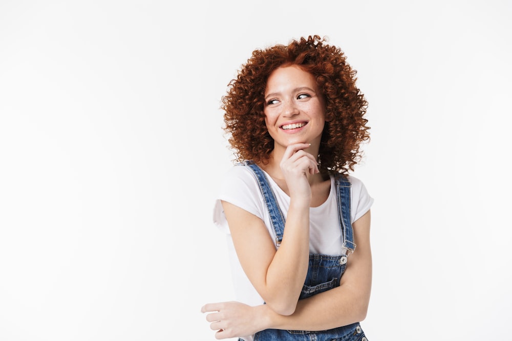 a woman in overalls posing for a picture