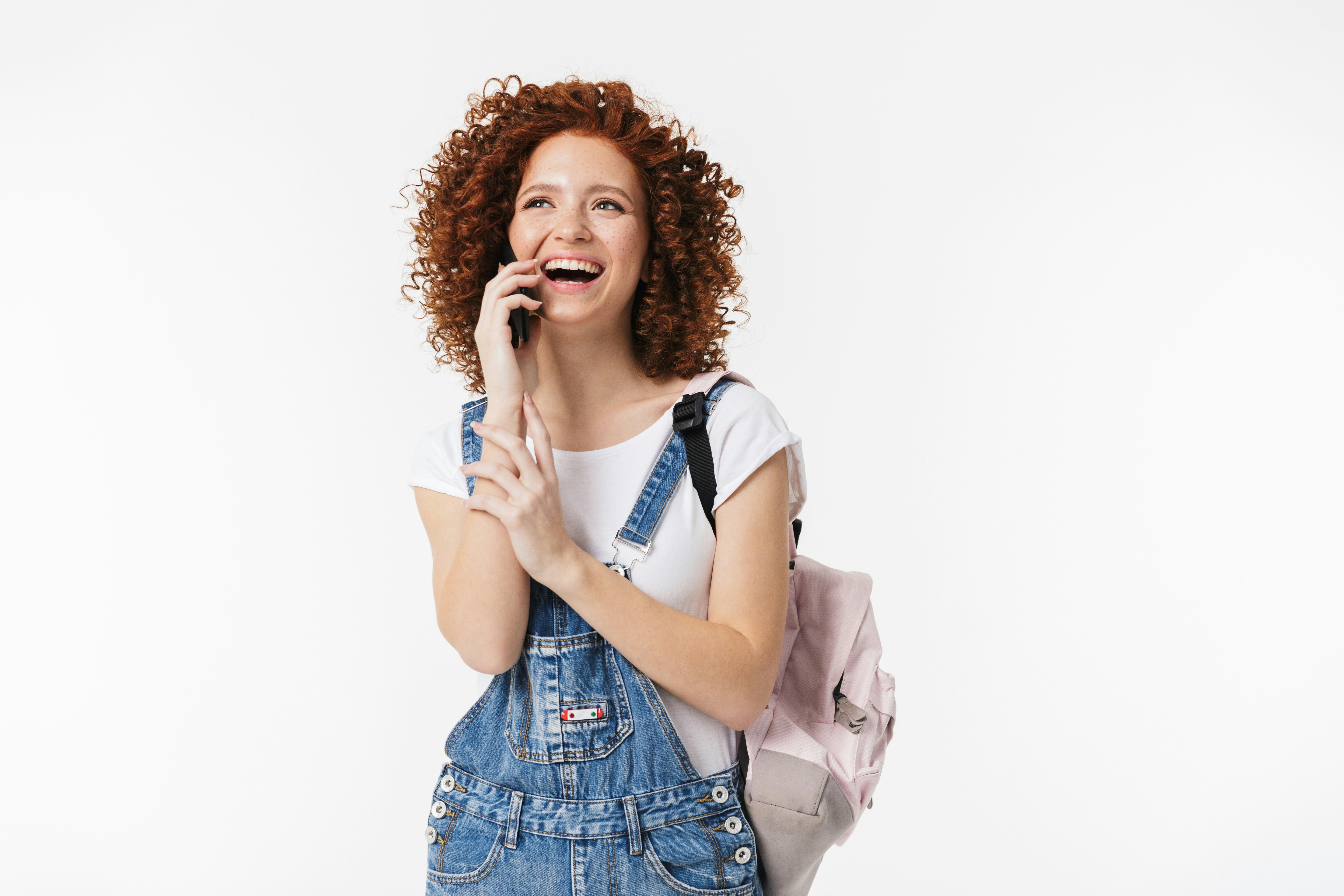 a woman with curly hair is holding a pink bag