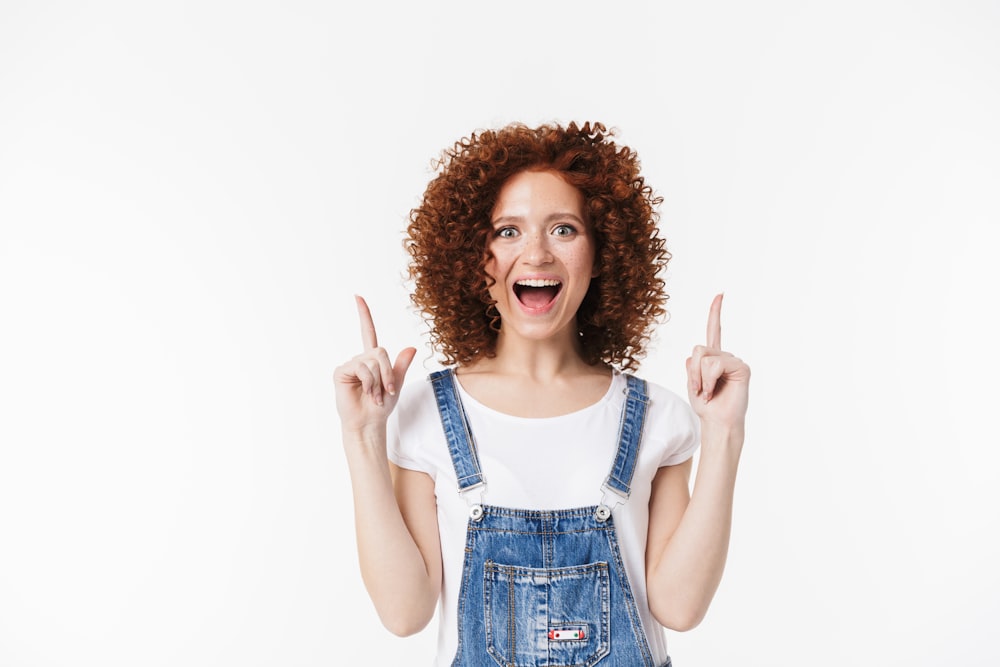 a woman in overalls making a peace sign