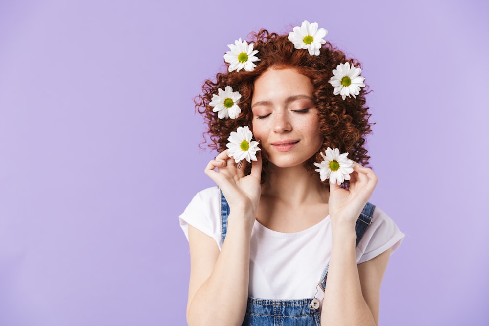 a woman with red hair and white flowers in her hair