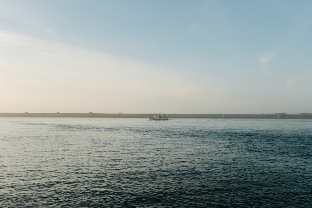 a large body of water with a boat in the distance