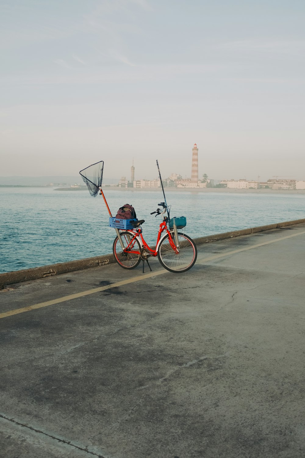 a bicycle parked on the side of a road next to the ocean