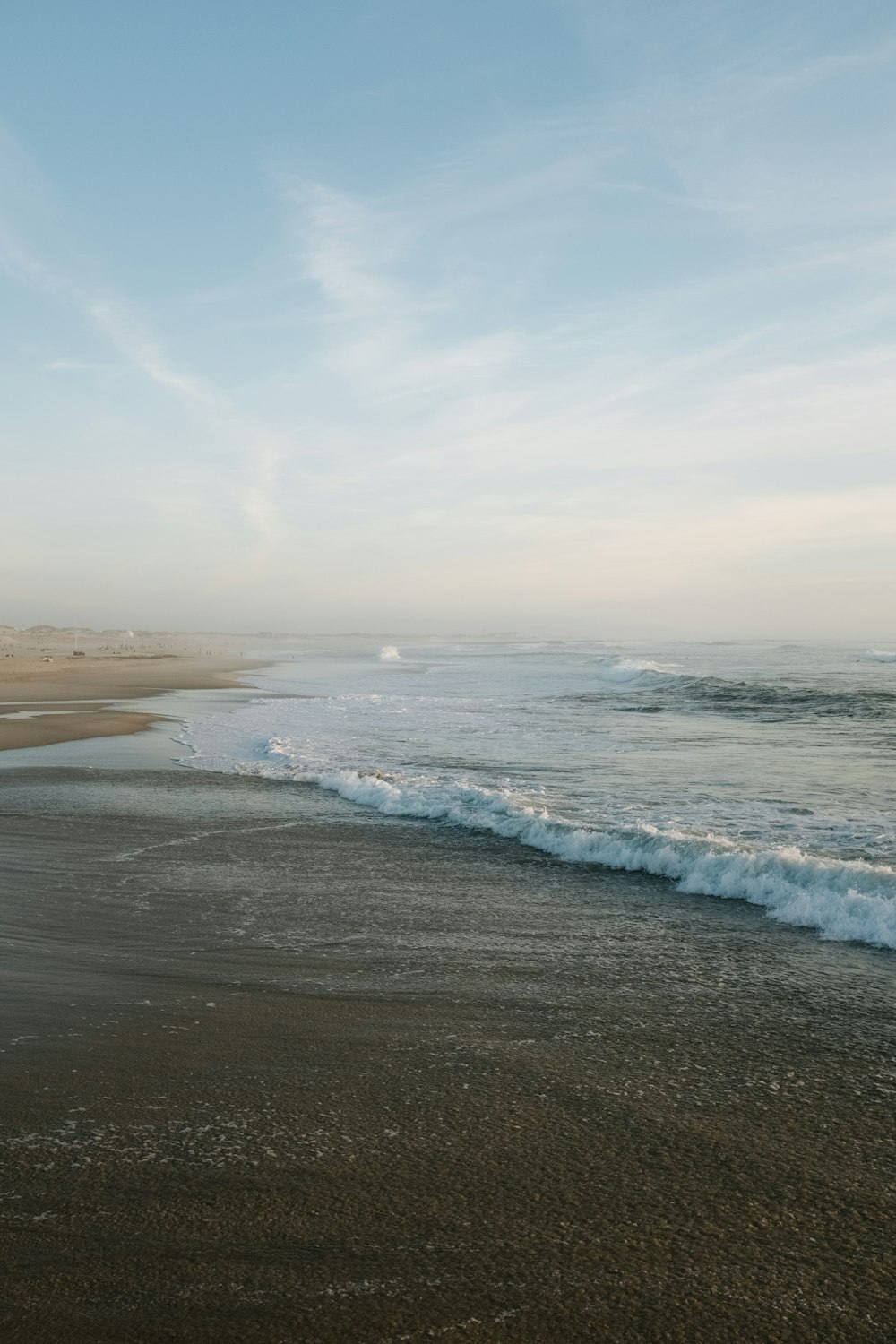 a sandy beach with waves coming in to shore