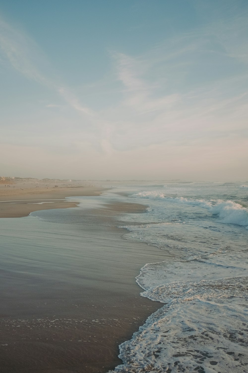 a sandy beach with waves coming in to shore