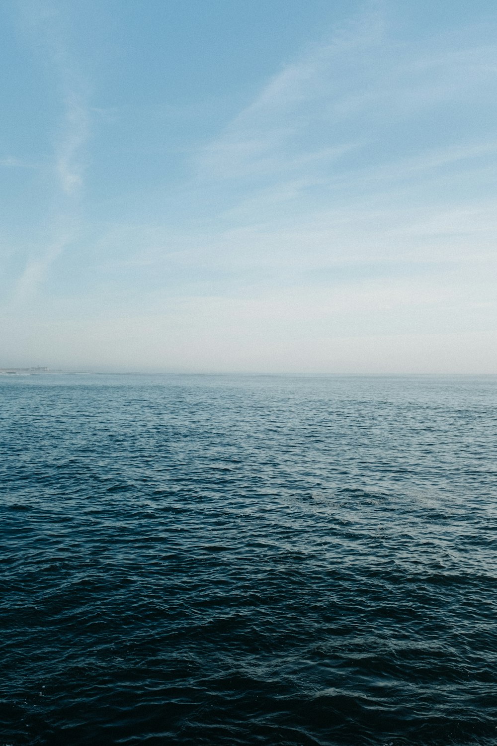 a large body of water sitting under a blue sky