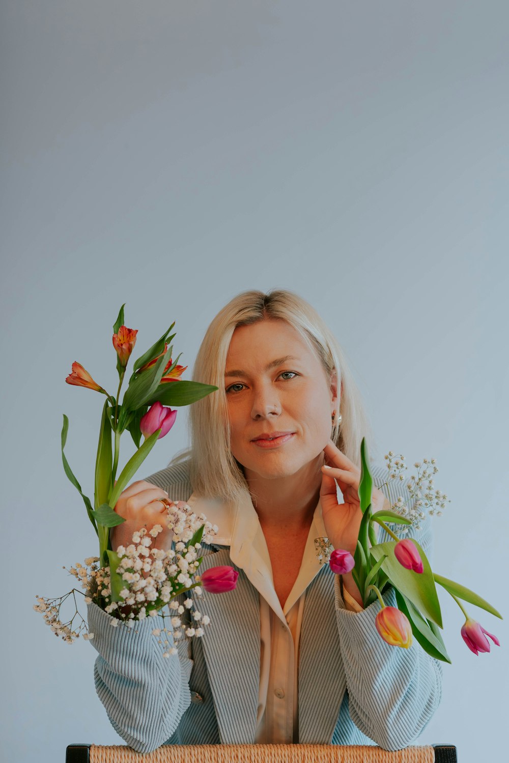 a woman holding a bunch of flowers behind her head