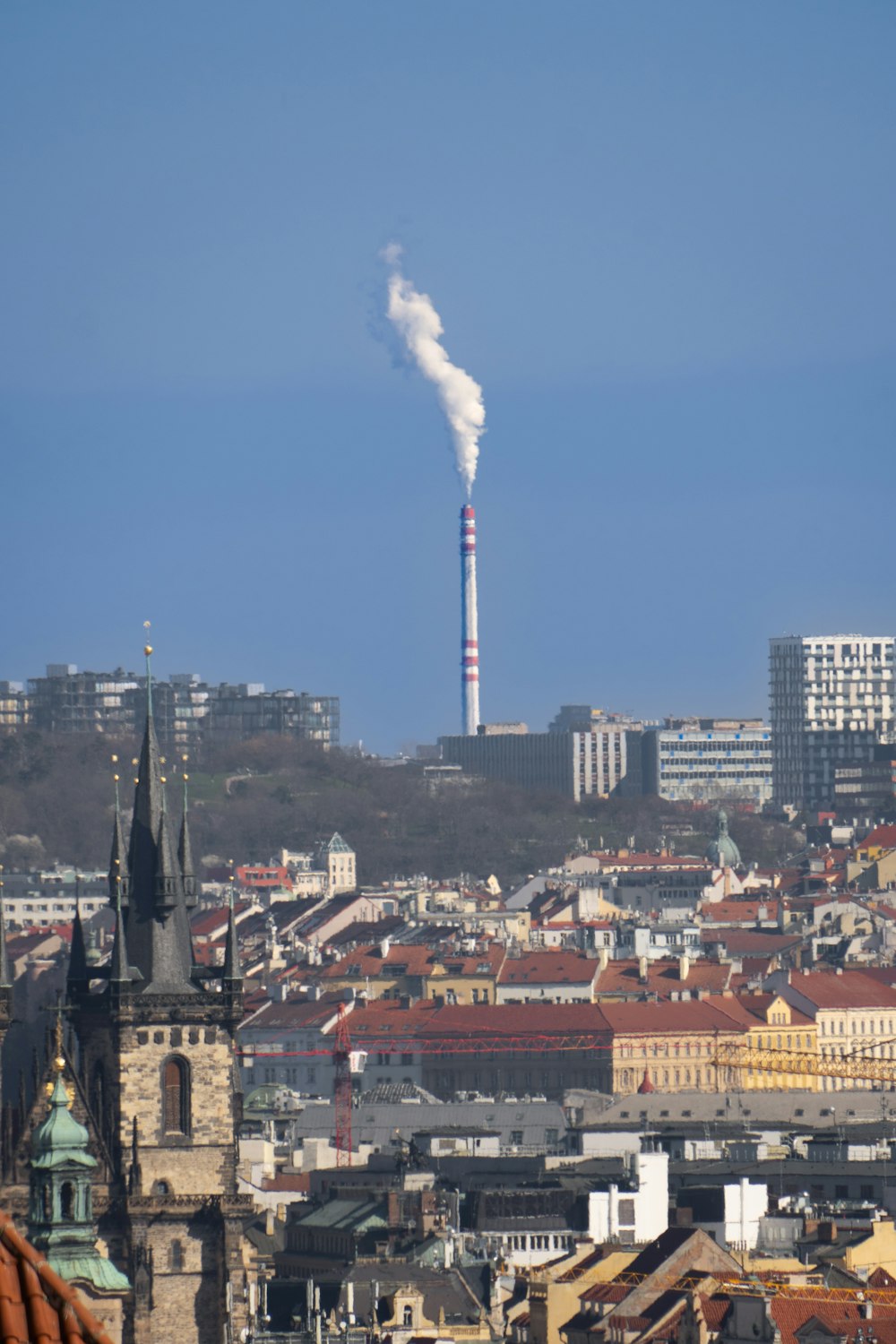 a smokestack emits from the top of a building in a city