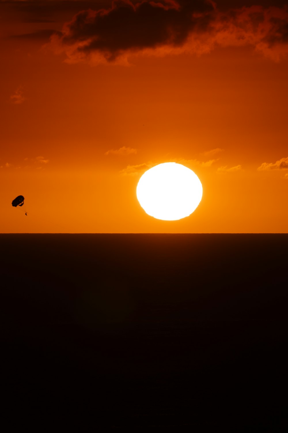 the sun is setting over the horizon of a large body of water