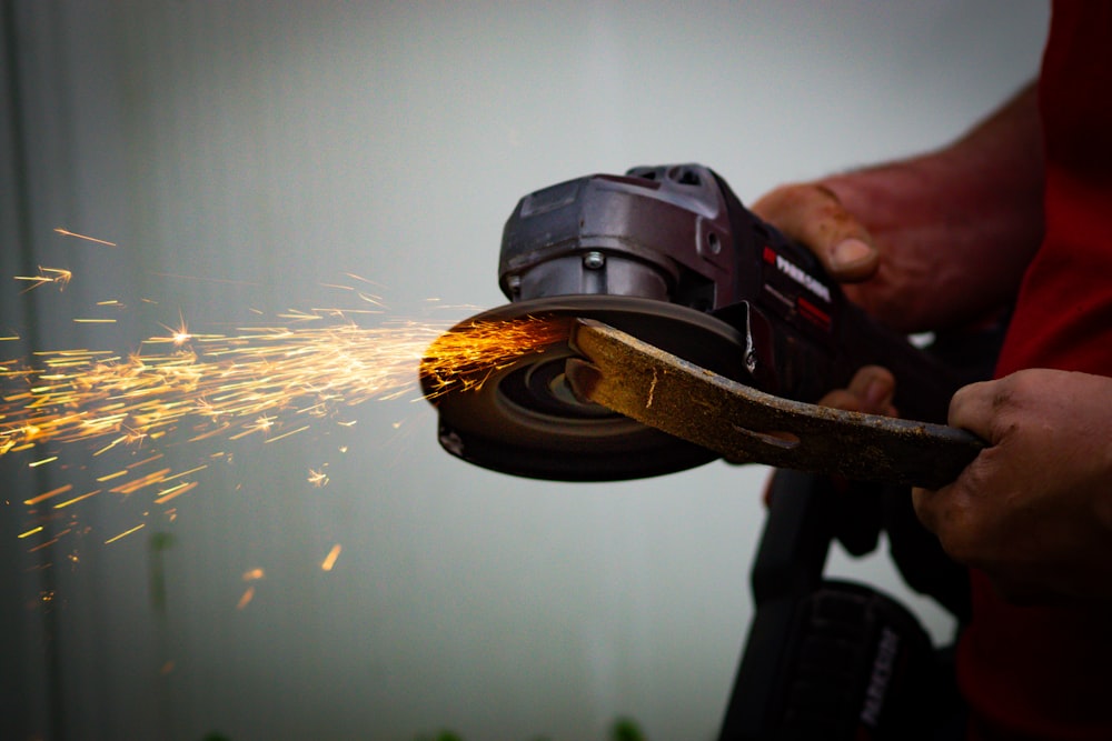 a person using a grinder on a piece of wood