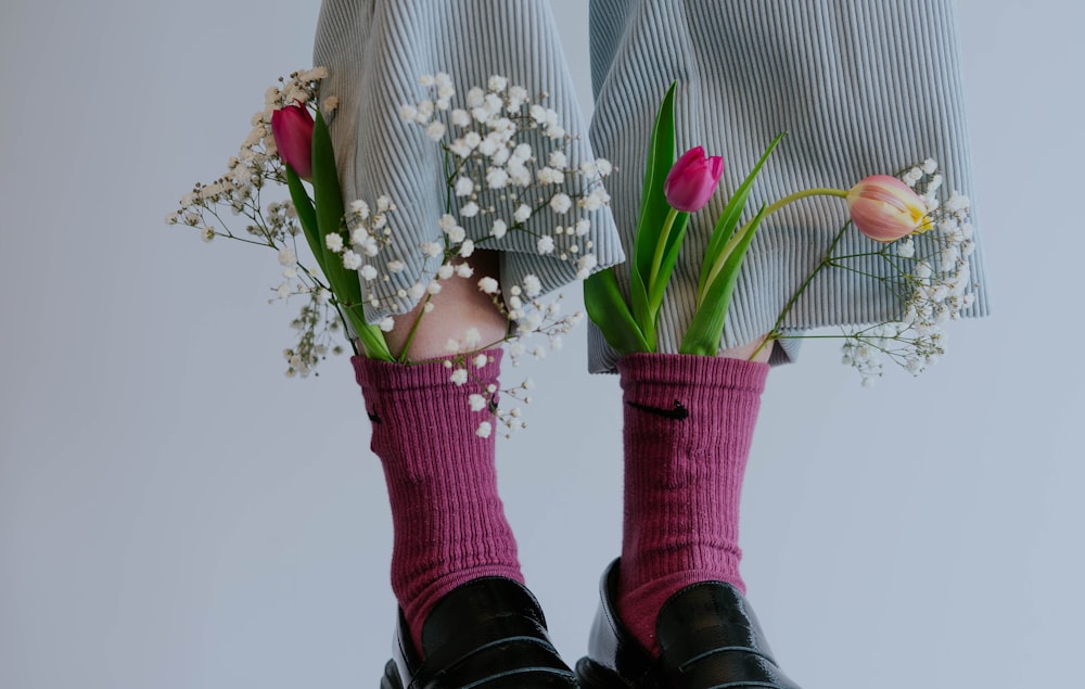 une paire de jambes avec des fleurs dans leurs chaussettes