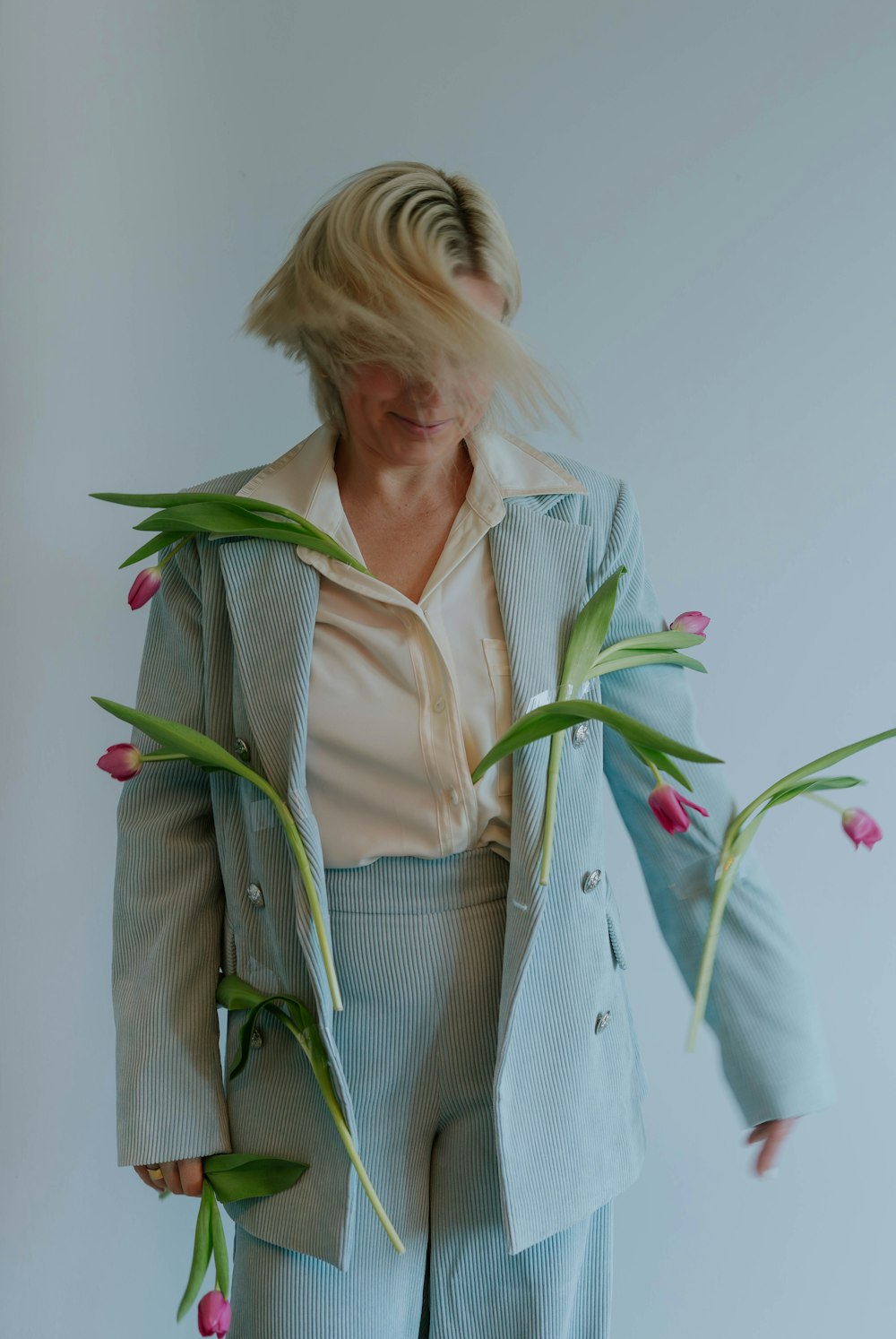 a woman in a suit with flowers in her hair